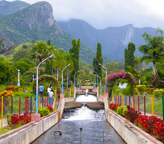 Beautiful landscaped Aliyar Dam Park with lush gardens, walking paths, and the Anamalai Hills in the background at the foothills of Valparai near Pollachi, Tamil Nadu.