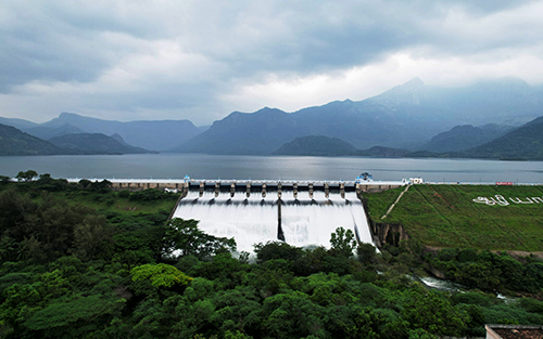 Scenic view of Aliyar Dam near Pollachi in Tamil Nadu, featuring the reservoir surrounded by the Anamalai Hills at the foothills of Valparai.